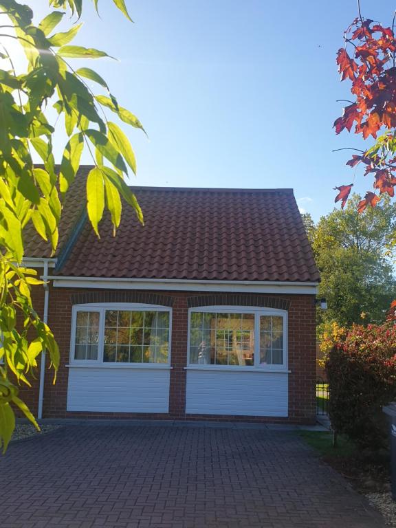 a red brick house with a white garage at Coastal Annex at Saltfleet in Louth