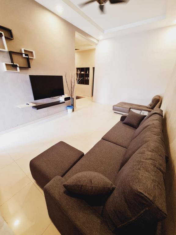 un soggiorno con divano e TV a schermo piatto di Air-home No135 Kampung Boyan, 3BR, 6pax Netflix a Taiping