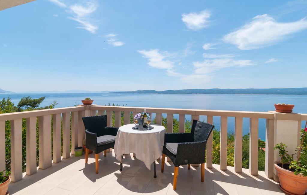 uma mesa e cadeiras numa varanda com vista para a água em Villa Anči em Pisak