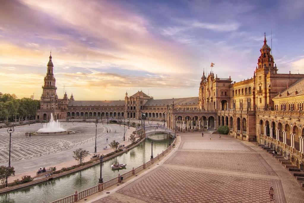 a large building with a fountain in a courtyard at Spalis Suite Loft de lujo en el centro histórico in Seville