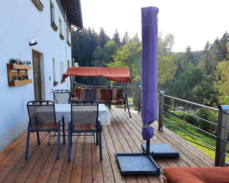 a patio with a table and chairs on a deck at Ferienwohnung Schäfer in Rinchnach