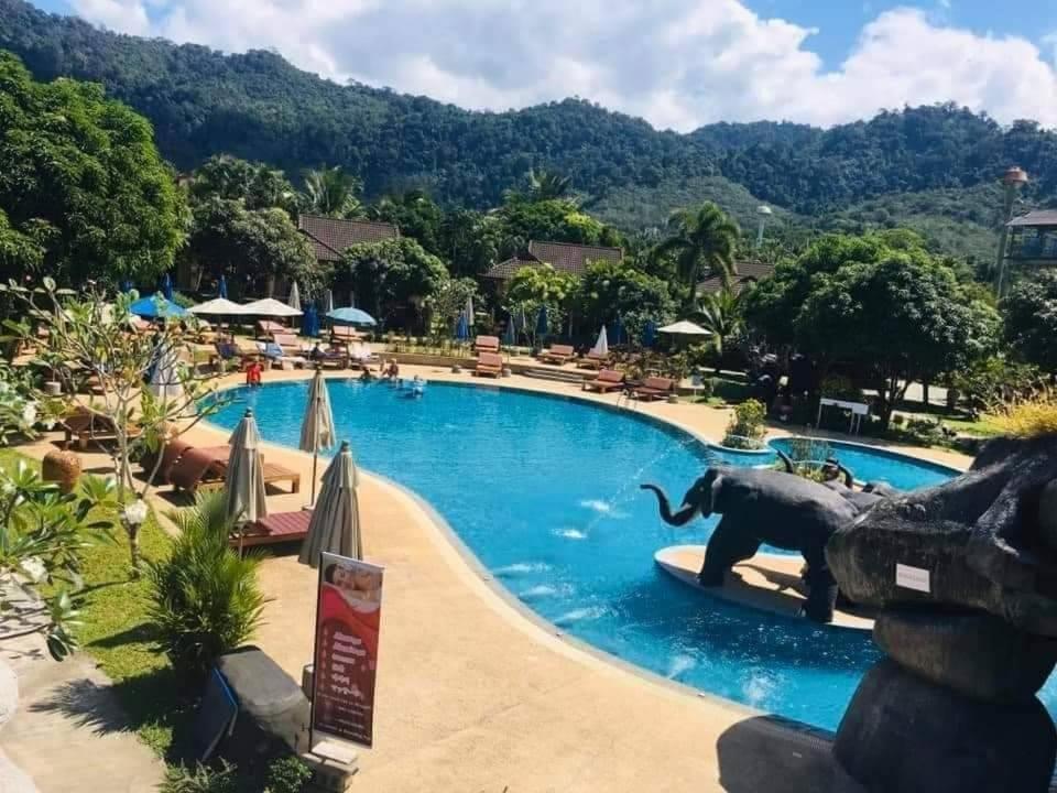 an elephant in the middle of a swimming pool at a resort at Happy Lagoon Bungalow in Khao Lak