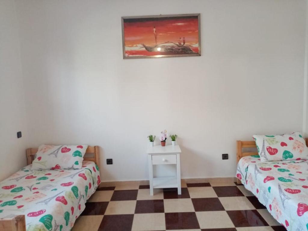 Grand Appartement à 5 mn de la plage في أغادير: غرفة نوم بسريرين وارضية مضلمة