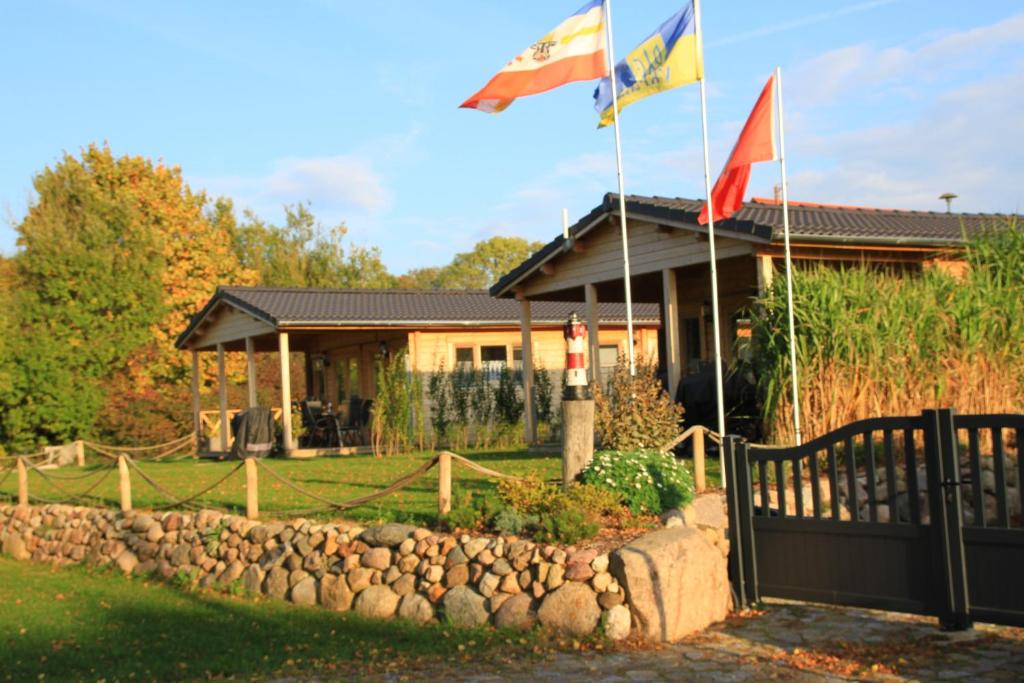 due bandiere volano davanti a una casa di Ferienhäuser Seeblick a Langenhagen