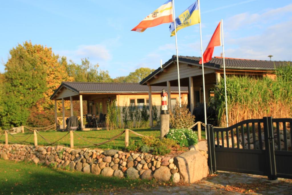 two flags flying in front of a house at Ferienhäuser Seeblick in Langenhagen