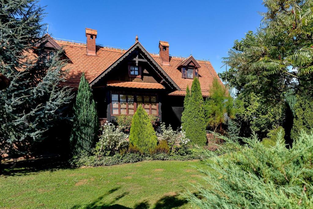 uma casa com um telhado vermelho e algumas árvores em OAK COTTAGE em Maruševec