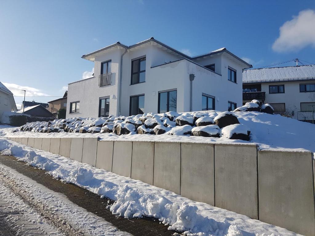 a group of sheep on top of a wall in the snow at Ferienwohnung Sonne in Stahlhofen