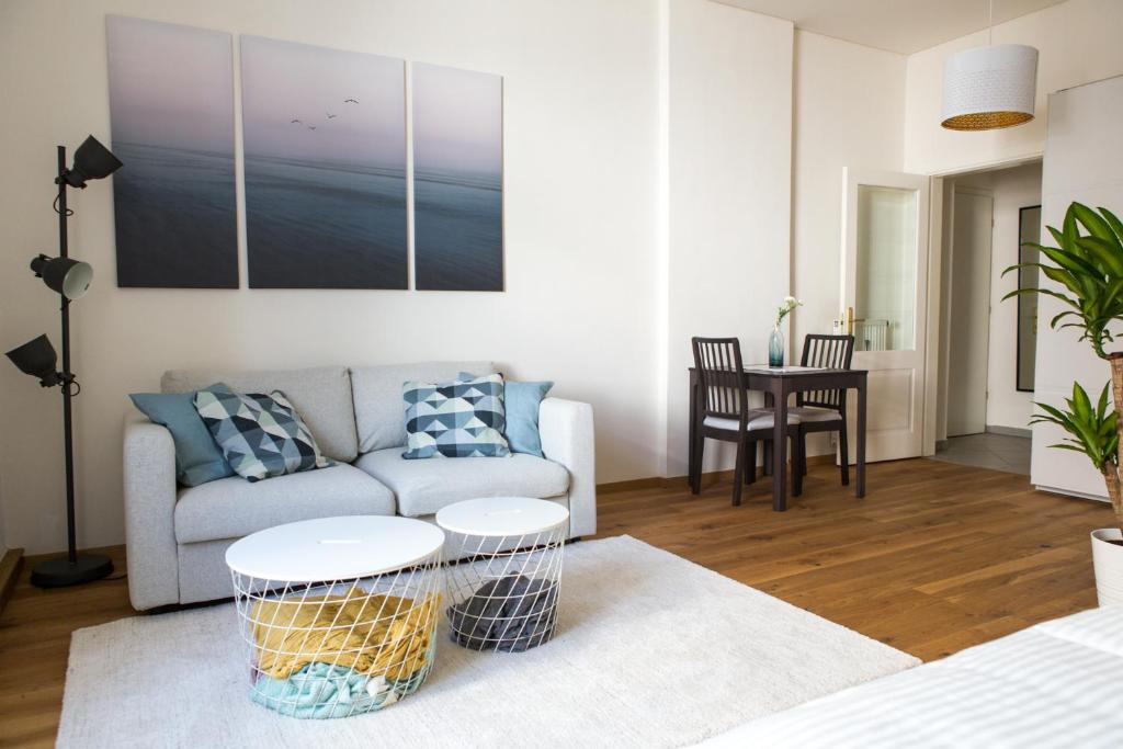 ein Wohnzimmer mit einem Sofa und einem Tisch in der Unterkunft Charming City Apartment in Graz