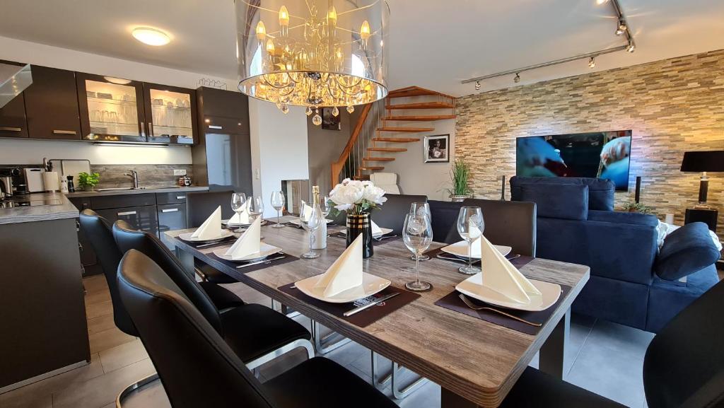 uma sala de jantar com uma mesa e um sofá azul em Luxusferienhaus Seevilla Monaco am Fleesensee em Göhren-Lebbin