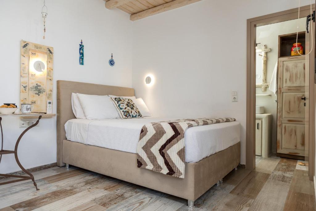 a bedroom with a bed with white sheets and a table at Elizabeth's small apartment in Naxos Chora