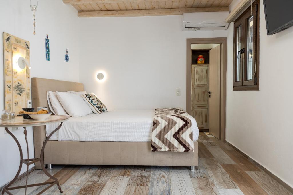 a white bedroom with a bed and a table at Elizabeth's small apartment in Naxos Chora
