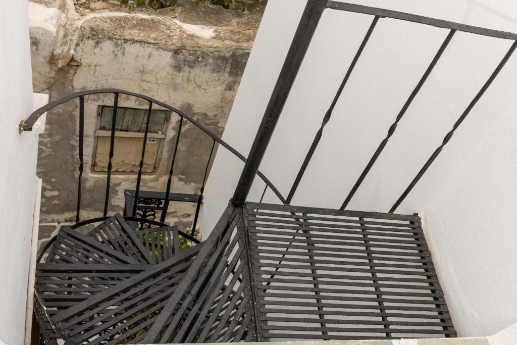 a staircase with a black metal railing next to a building at Elizabeth's small apartment in Naxos Chora