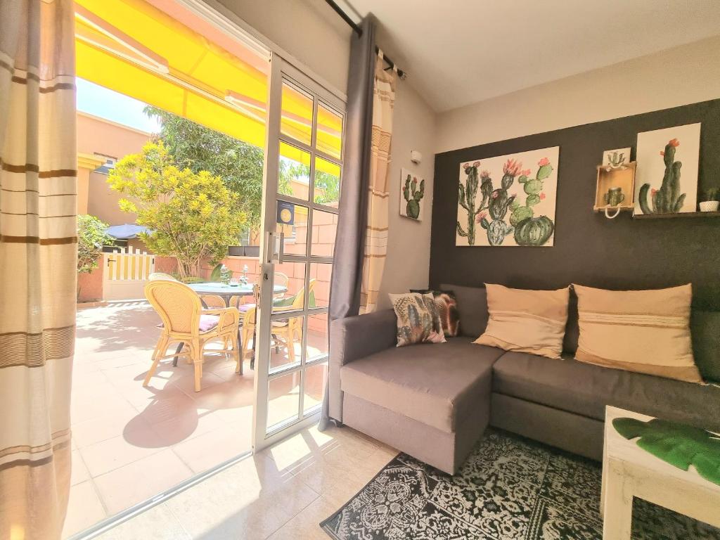 a living room with a couch and a table at Top1 Green Sea Bungalow jardin in Maspalomas