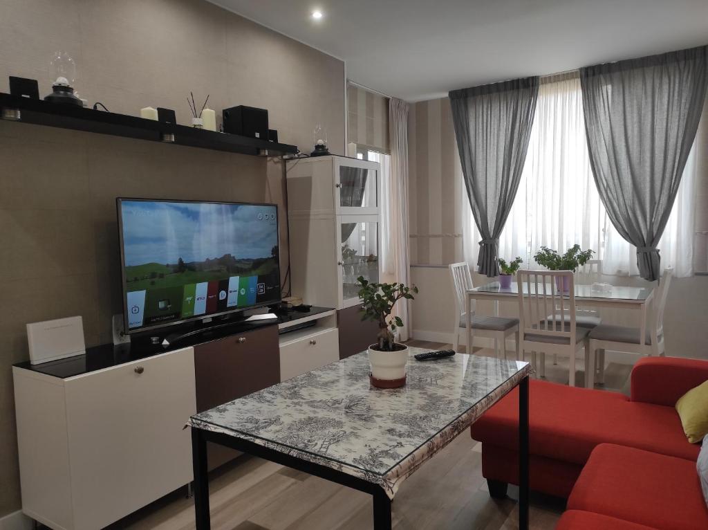 a living room with a red couch and a television at La Colina - Playamar Apartamento in Torremolinos