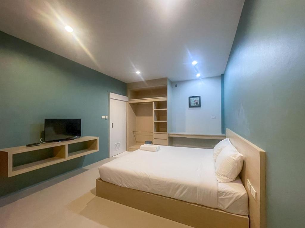 a large bedroom with a bed and a tv at Hop On Phuket in Ban Bo Han