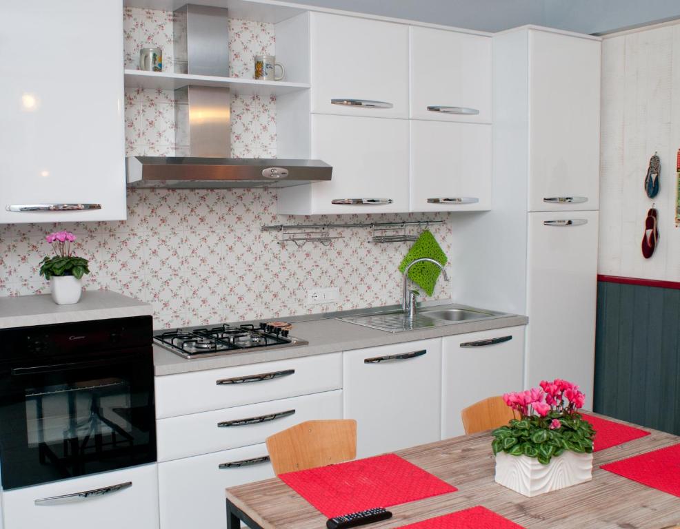 eine Küche mit weißen Schränken und einem Holztisch in der Unterkunft Tami Holidays in Vittorio Veneto