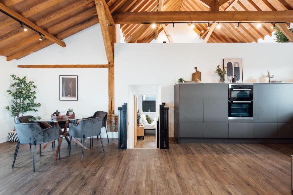 uma cozinha e sala de jantar com mesa e cadeiras em The Honeybee's Nest - Semi-rural Barn Conversion close to Leavesden Studios em Leverstock Green