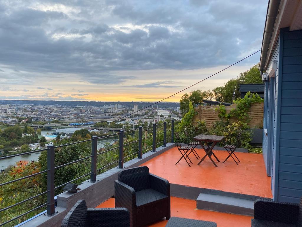 a balcony of a house with a table and chairs at La colline bleue in Rouen