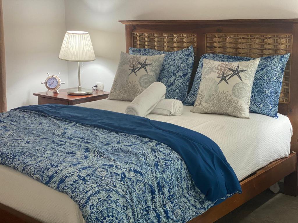 ein Schlafzimmer mit einem Bett mit blauer Bettdecke und Kissen in der Unterkunft Espectacular BZII, bayahibe in Bayahibe