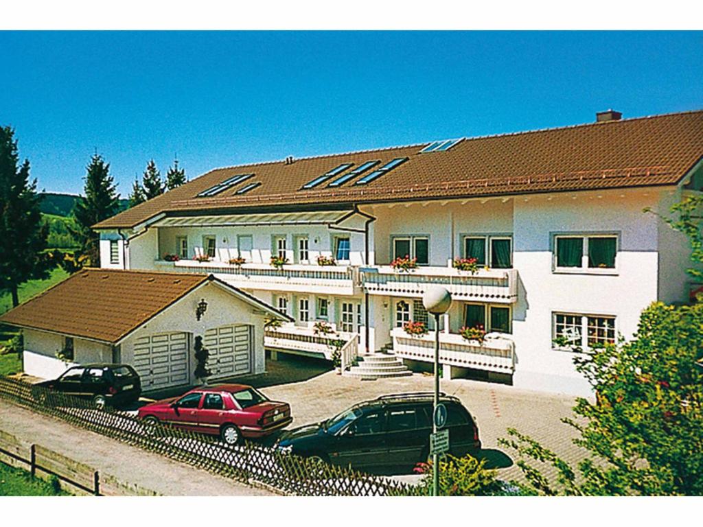 een groot wit huis met auto's geparkeerd voor het bij Appartementhaus Viktoria in Bad Birnbach