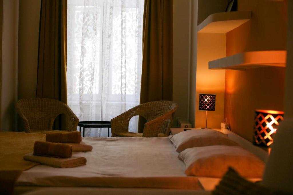 una camera da letto con un letto con due sedie e una finestra di Black Church Studio a Braşov