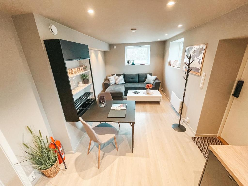 een kleine woonkamer met een bank en een tafel bij Unik liten leilighet i Stamsund, midt i Lofoten in Rishaugen