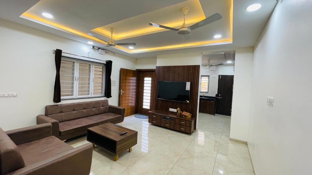 a living room with a couch and a flat screen tv at Luxurious 3 BHK Villa In Bhuj - Shivani Homestay in Bhuj