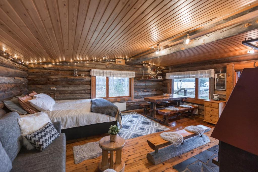 a log cabin bedroom with a bed and a table at Lapland Northern Lights Cabin - Wooden Sauna in Rovaniemi