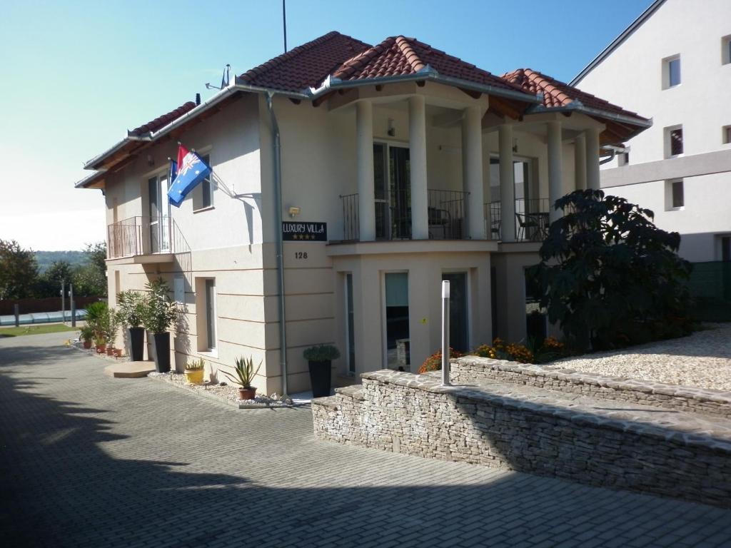 um edifício com uma bandeira à sua frente em Luxury Villa Heviz em Hévíz