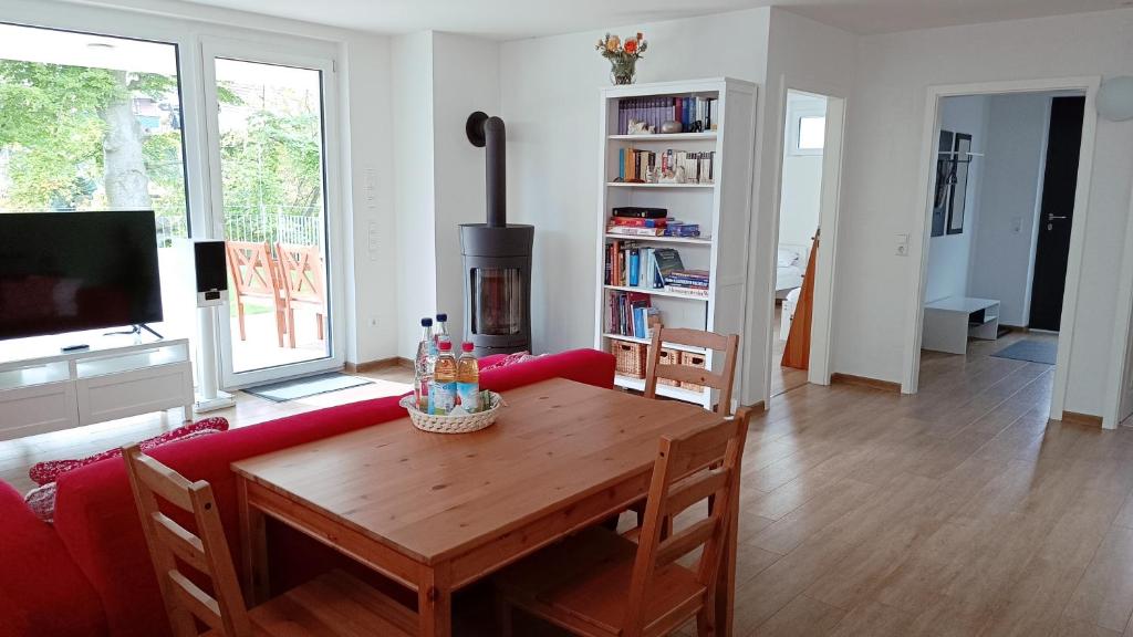 un soggiorno con divano rosso e tavolo in legno di Apartment Baumeister a Weilheim an der Teck