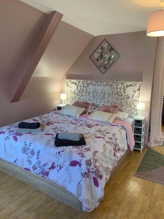 a bedroom with a large bed with a floral bedspread at Le Grenier studio de charme centre historique in Dinan
