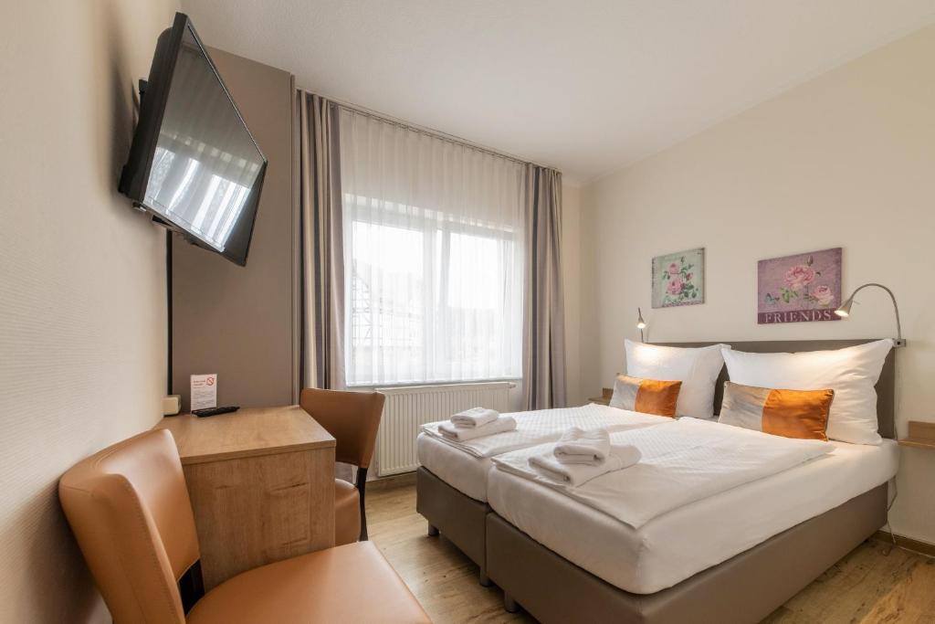 una camera d'albergo con un letto e una televisione di Hotel Bamberger Hof, garni a Eisenach