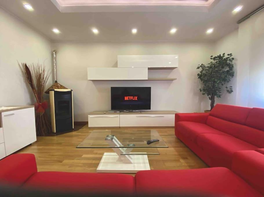 a living room with a red couch and a tv at Il Rifugio di Greta in Ceparana