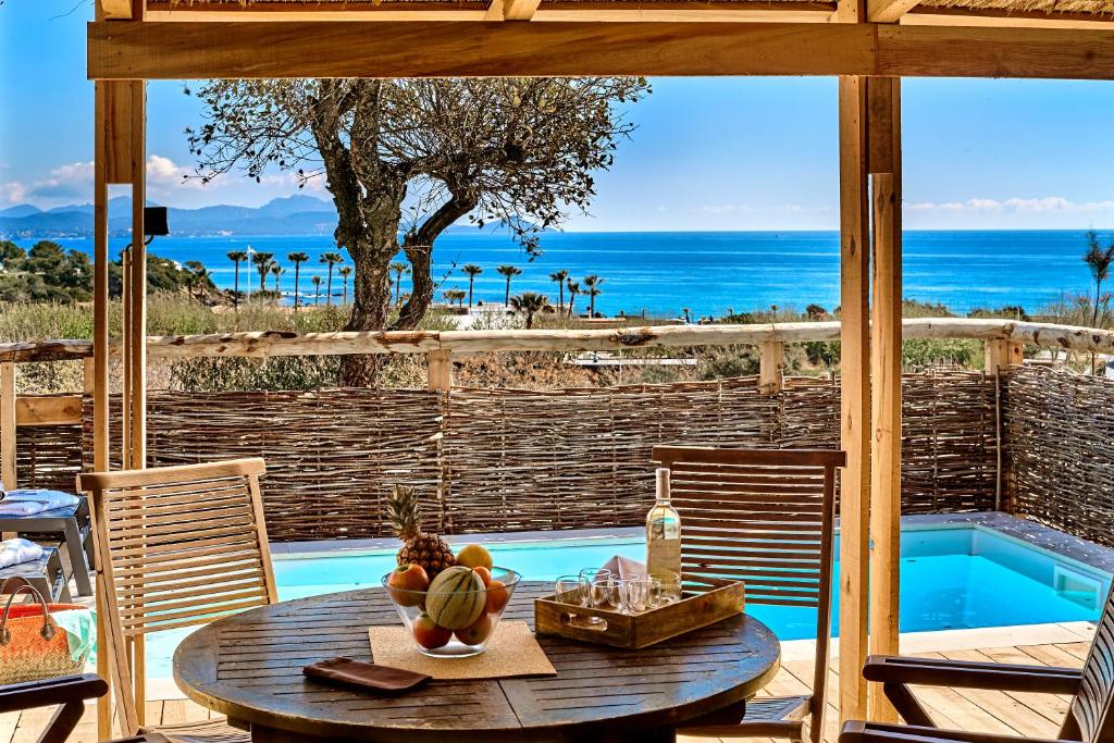 a patio with a table with a view of the ocean at Au Paradis des Campeurs in Les Issambres