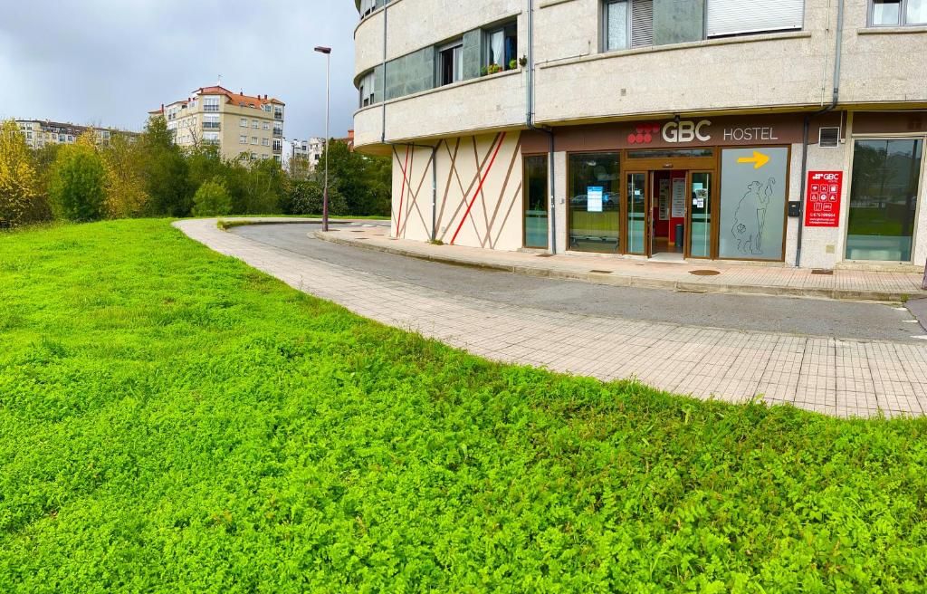 a building that is in the middle of a grassy area at Albergue GBC Hostel in Pontevedra