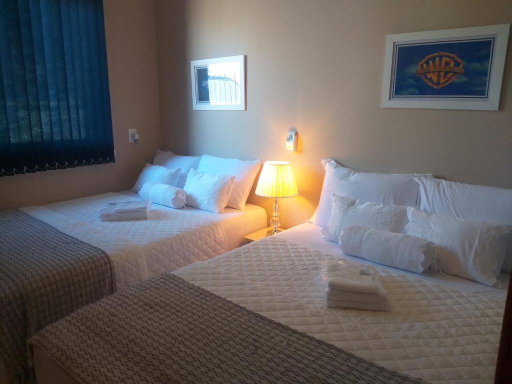 a hotel room with two beds and a lamp at Casa 3 Encanto dos Mares in Barra Velha