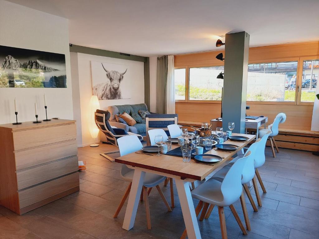 ein Esszimmer mit einem Tisch und blauen Stühlen in der Unterkunft Le Fleuron - Cosy and well centered - 6 ppl in Nendaz