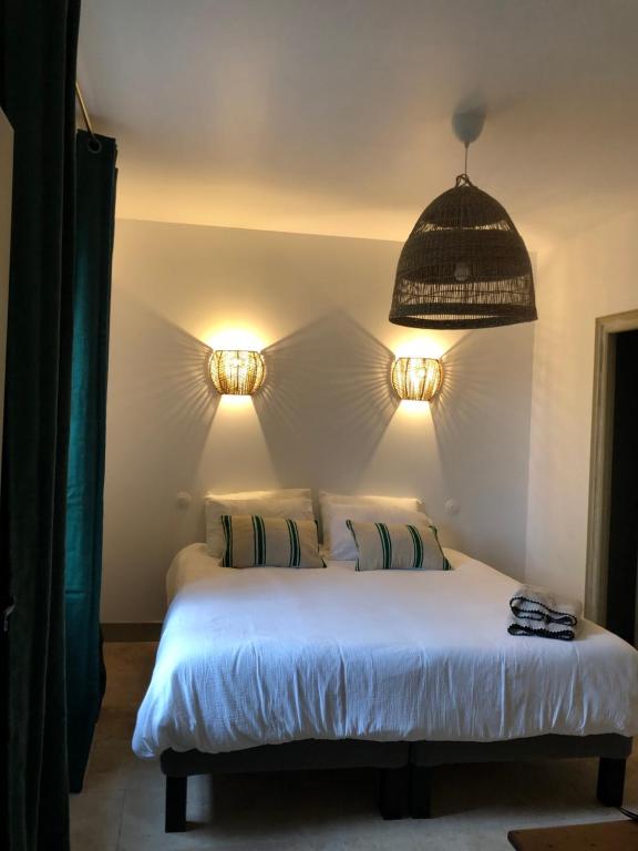 a bedroom with a white bed with two pillows at MANOIR DE CLERMONT in Saint Malo