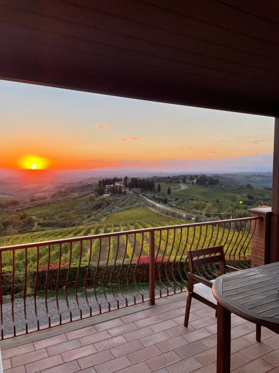 een uitzicht op de zonsondergang vanaf het balkon van een huis bij Podere Ghiole in Montespertoli