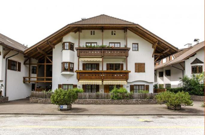 a large white building with a large balcony at Hernegg Apartment in Riscone