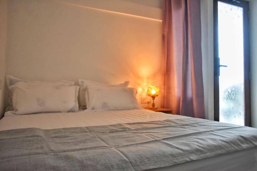 a bed with white pillows and a window at TravelRim Maldives in Dhiffushi