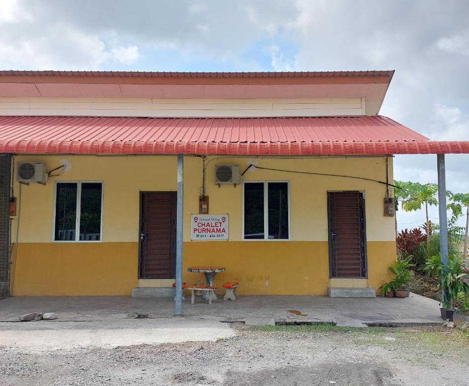 a yellow and red building with a red roof at Chalet Purnama in Alor Setar