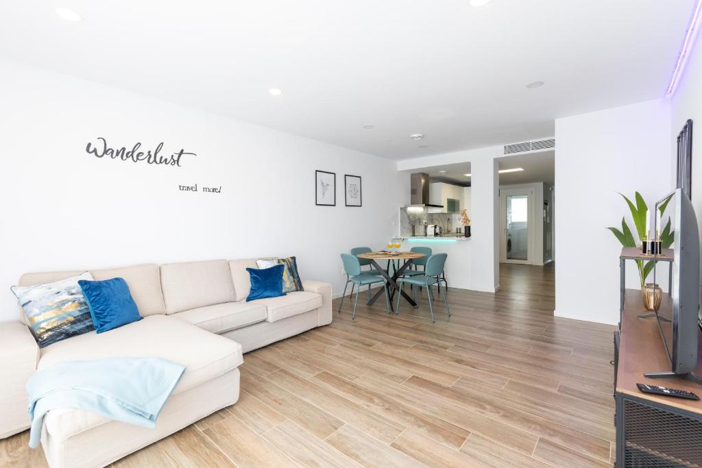 a living room with a white couch and a table at Fabuloso Apartamento nuevo con Parking y Piscina in Málaga