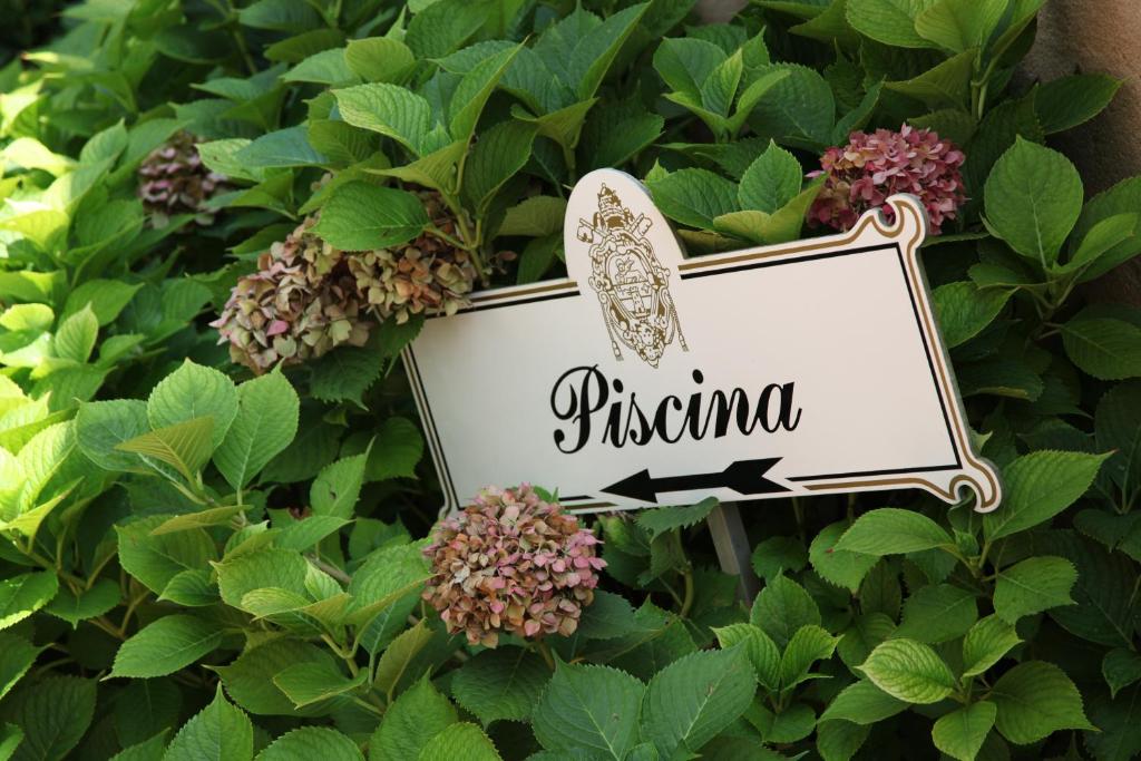 a sign in a bush with a butterfly on it at Albergo Ristorante Papa in Peschiera del Garda