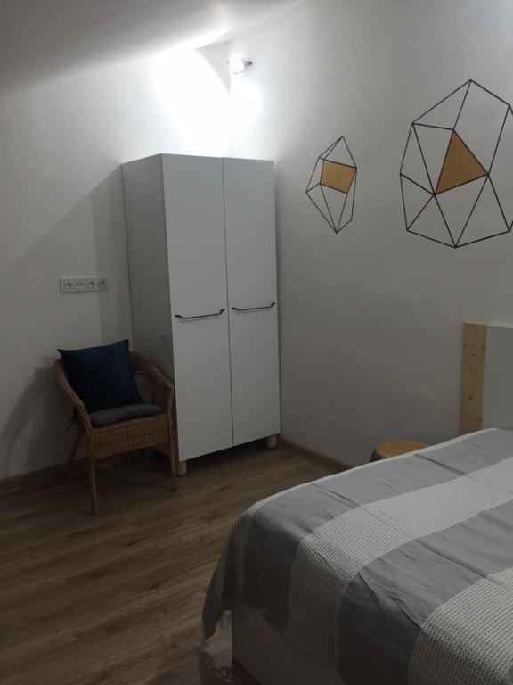 1 dormitorio con 1 cama, armario y silla en apartment 7, en Ereván