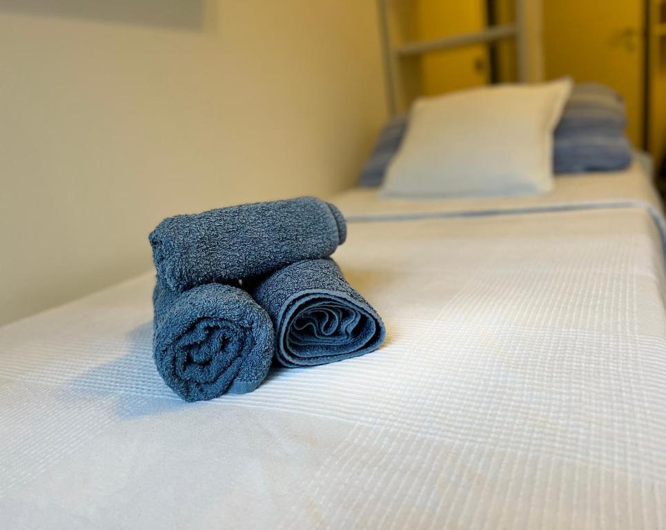 stos ręczników leżący na łóżku w obiekcie A 5 minuti dal mare - Dolphin Beach House w mieście Spotorno