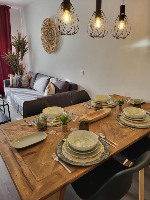 una mesa de madera con platos en la sala de estar en Alazán Jerez II-Parking gratis-wifi-Netflix, en Jerez de la Frontera