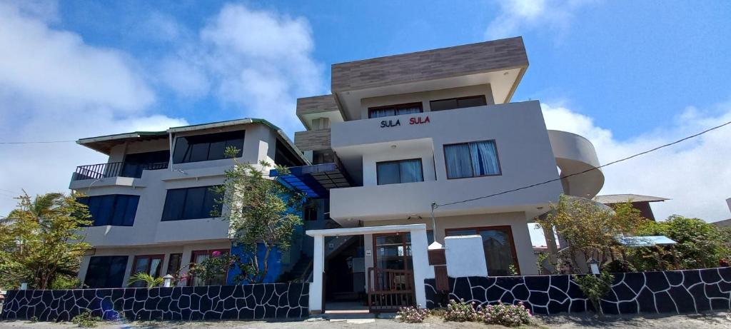 un edificio blanco alto con las palabras cuadrado en él en Hotel Sula Sula, en Puerto Villamil