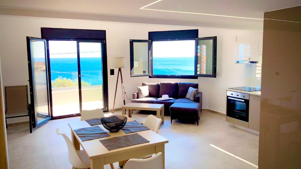 un soggiorno con divano e tavolo di Crete Southside Villas Tris Ekklisies a Paránimfoi