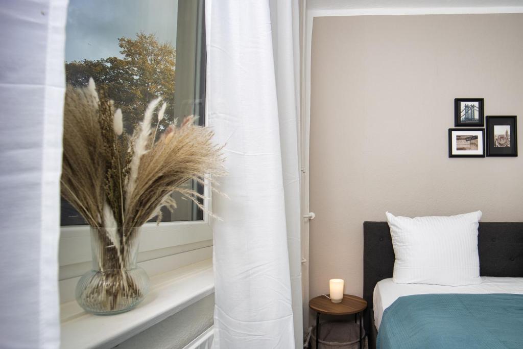 a bedroom with a window with a vase on a window sill at HejU - Altbau meets Design - Parkplatz - Netflix in Lübeck